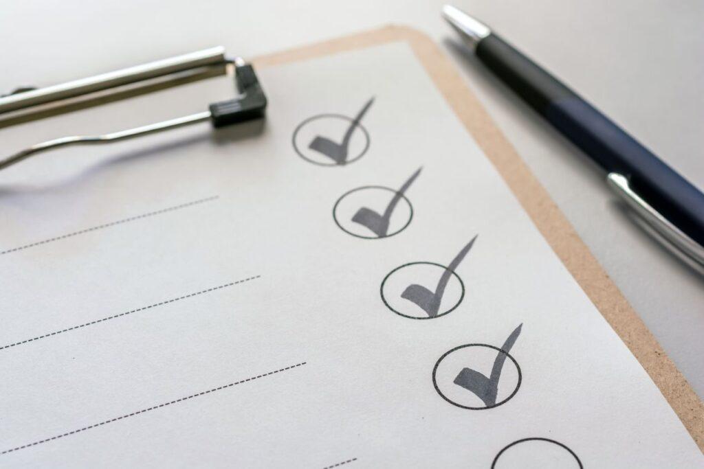 Checkliste und Stift auf Klemmbrett zur Planung und Organisation beim Bachelorarbeiten schreiben lassen